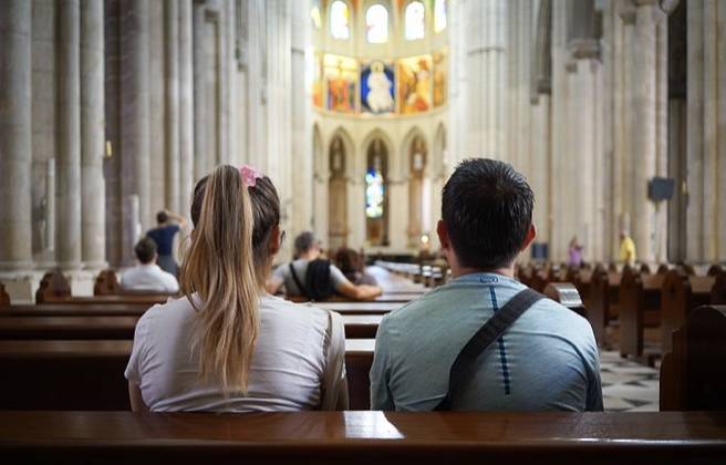 A picture of two persons in a church