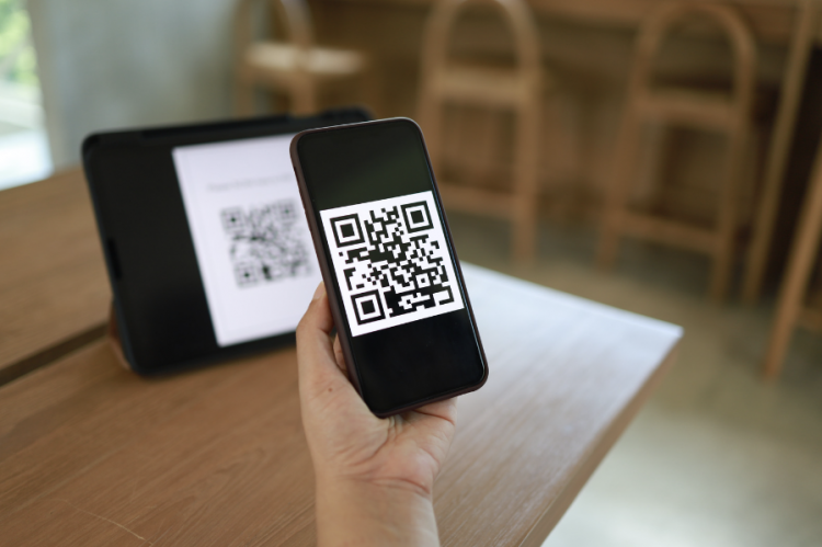 A picture of a person using cell phone scanning a QR code
